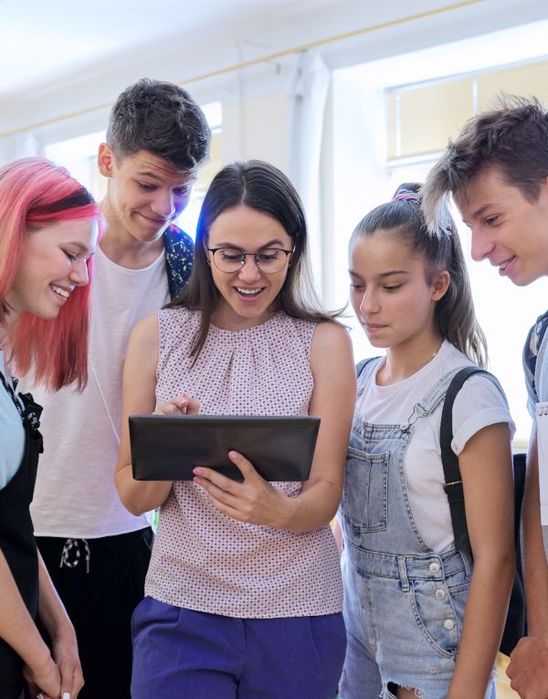 Grupo de estudiantes y profesora mirando la pantalla de una tablet. Concepto de formación.